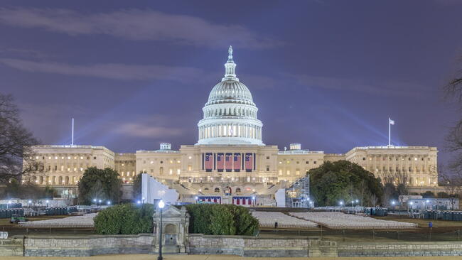 The West side of the US Capitol Building as it is prepared for the 58th presidential inauguration ceremony. The platform has been created and four of the five flags have been hung.