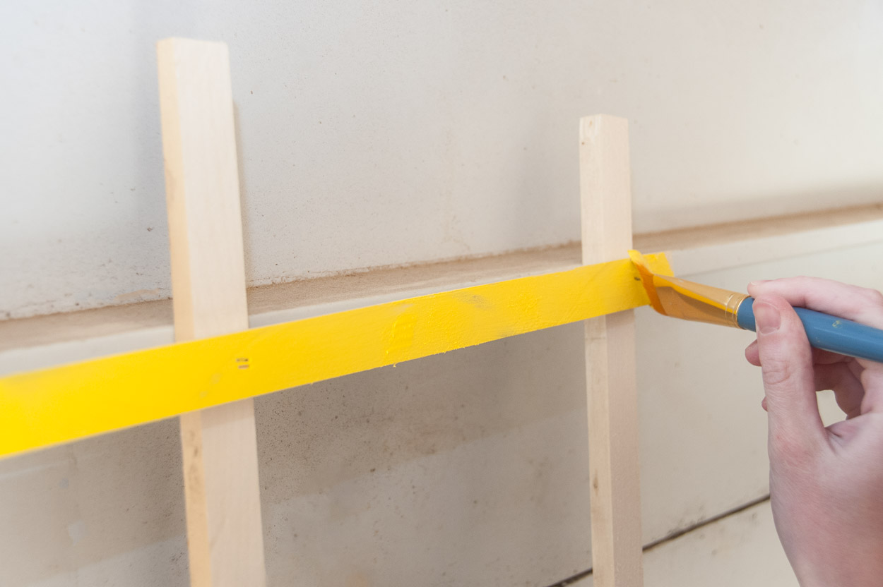 Painting the trellis yellow.